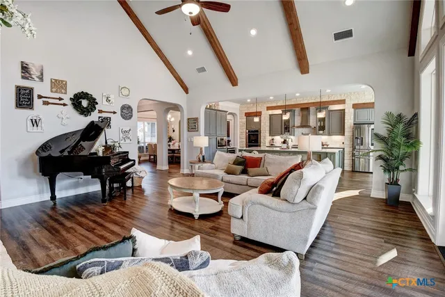 a kitchen with stainless steel appliances kitchen island granite countertop a table chairs sink refrigerator and microwave