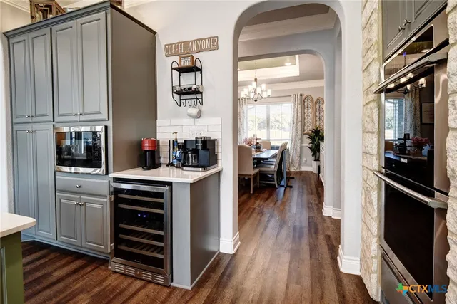 a kitchen with stainless steel appliances granite countertop a stove a sink dishwasher a refrigerator and a dining table with wooden floor