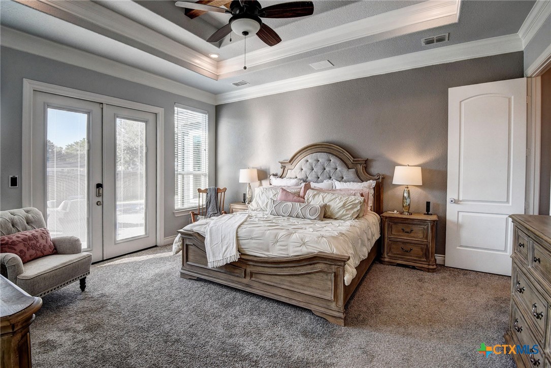 222 August Avenue Shiner, TX 77984 - Photo 23 of 48 a spacious bedroom with a bed a couch and a ceiling fan