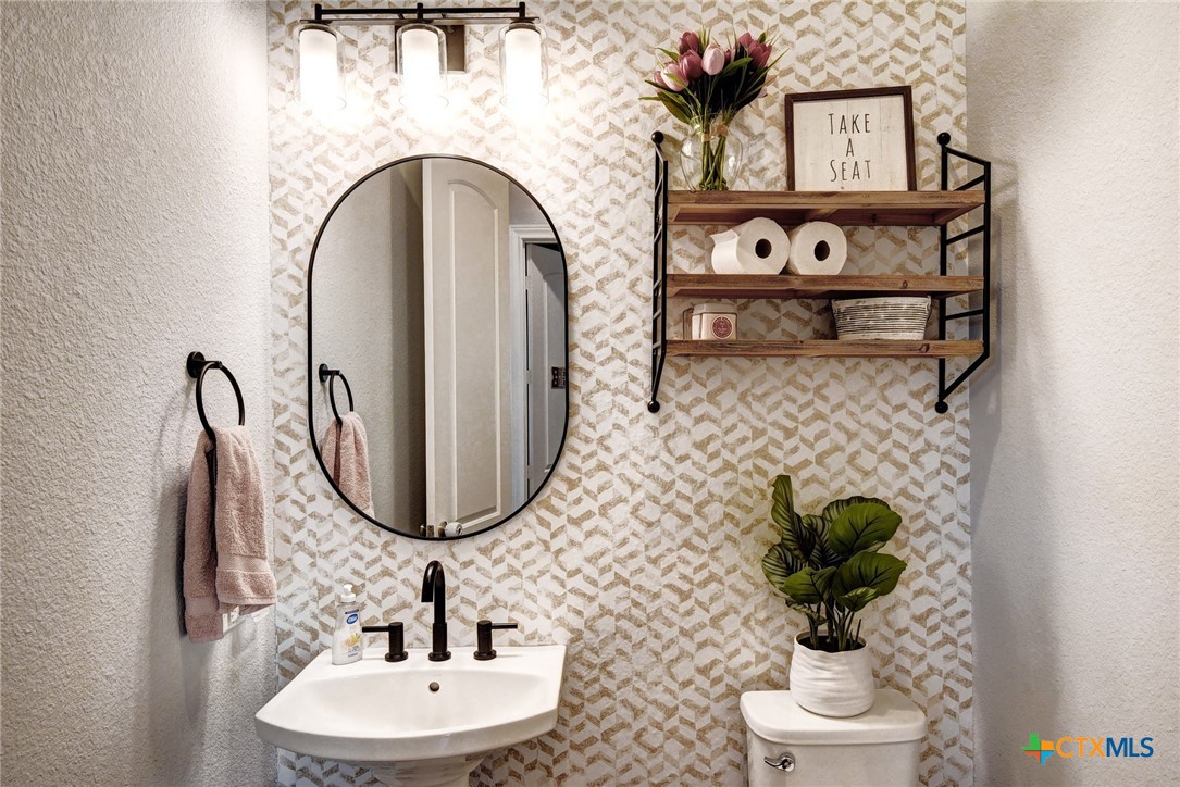 222 August Avenue Shiner, TX 77984 - Photo 40 of 48 a bathroom with a toilet sink and mirror