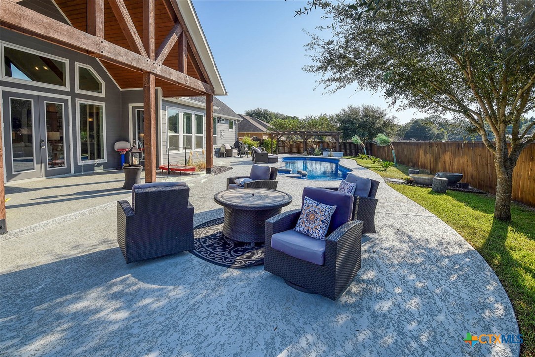 222 August Avenue Shiner, TX 77984 - Photo 43 of 48 a view of a patio with table and chairs potted plants with wooden floor and fence