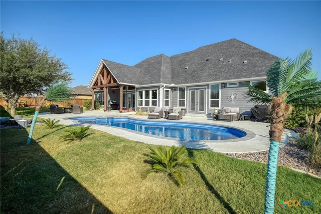 a view of a house with a big yard and sitting area