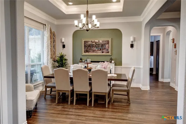 a living room with furniture a flat screen tv and kitchen view
