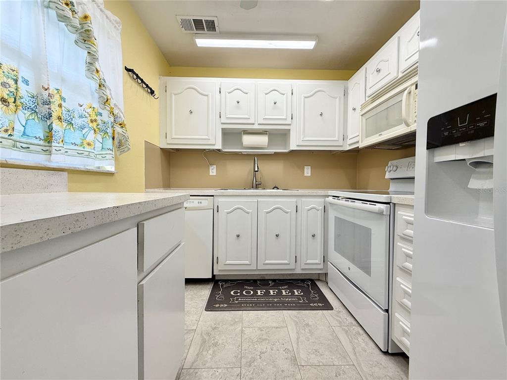 11817 Bayonet Lane New Port Richey, FL 34654 - Photo 2 of 32 a kitchen with a sink a stove and cabinets
