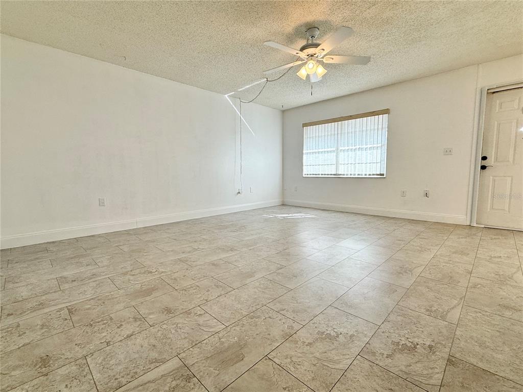11817 Bayonet Lane New Port Richey, FL 34654 - Photo 6 of 32 an empty room with windows and ceiling fan