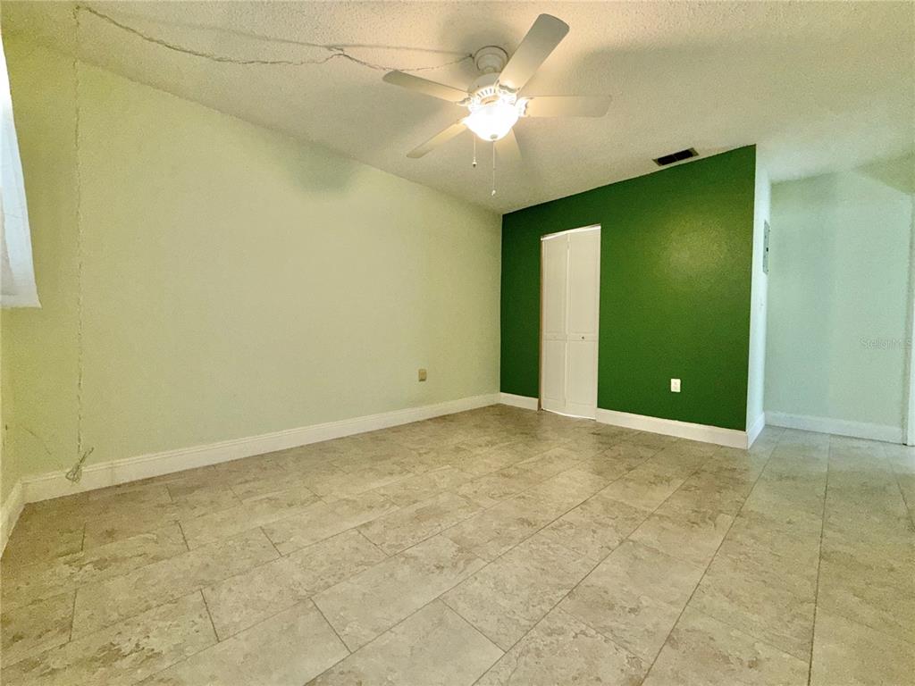 11817 Bayonet Lane New Port Richey, FL 34654 - Photo 10 of 32 an empty room with a chandelier fan and windows