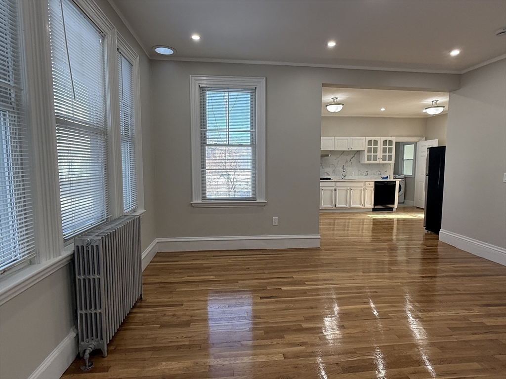 6 Channing Street, Unit 1 Newton, MA 02458 - Photo 2 of 16 a view of an empty room with wooden floor and a window