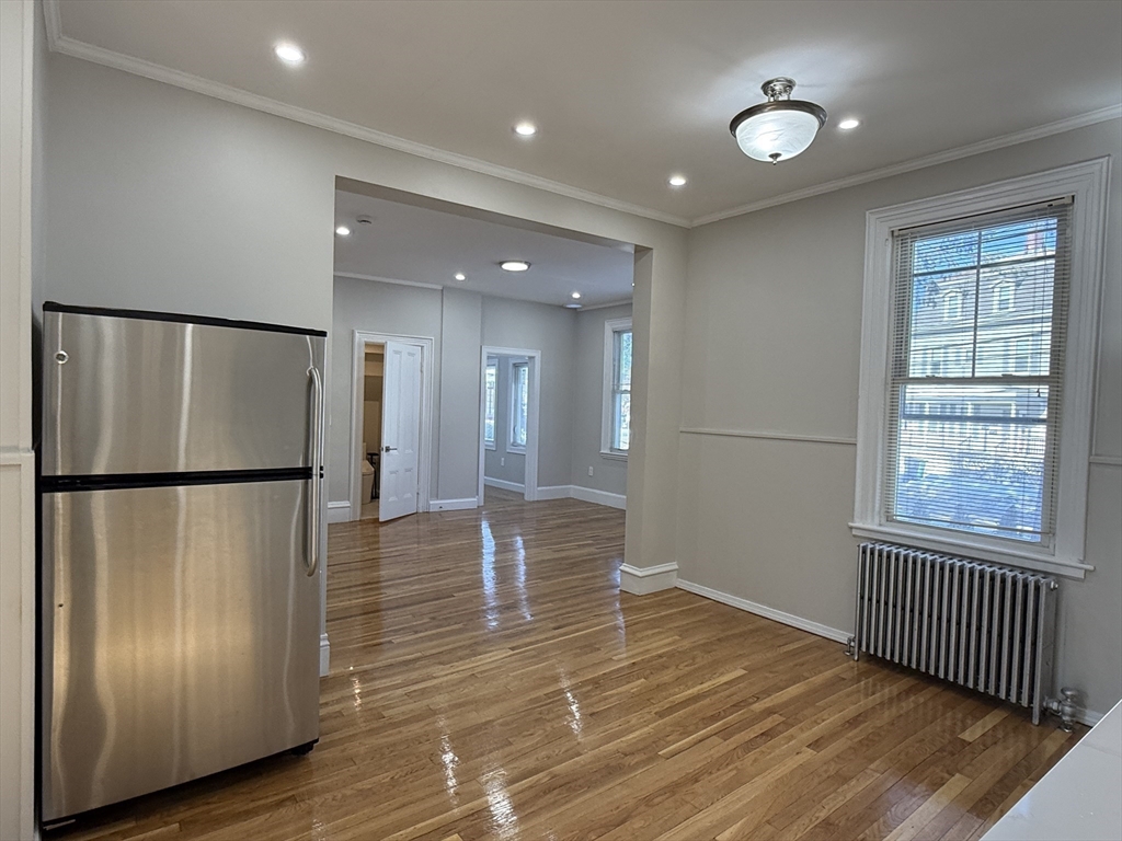 6 Channing Street, Unit 1 Newton, MA 02458 - Photo 3 of 16 a view of a refrigerator in kitchen and wooden floor