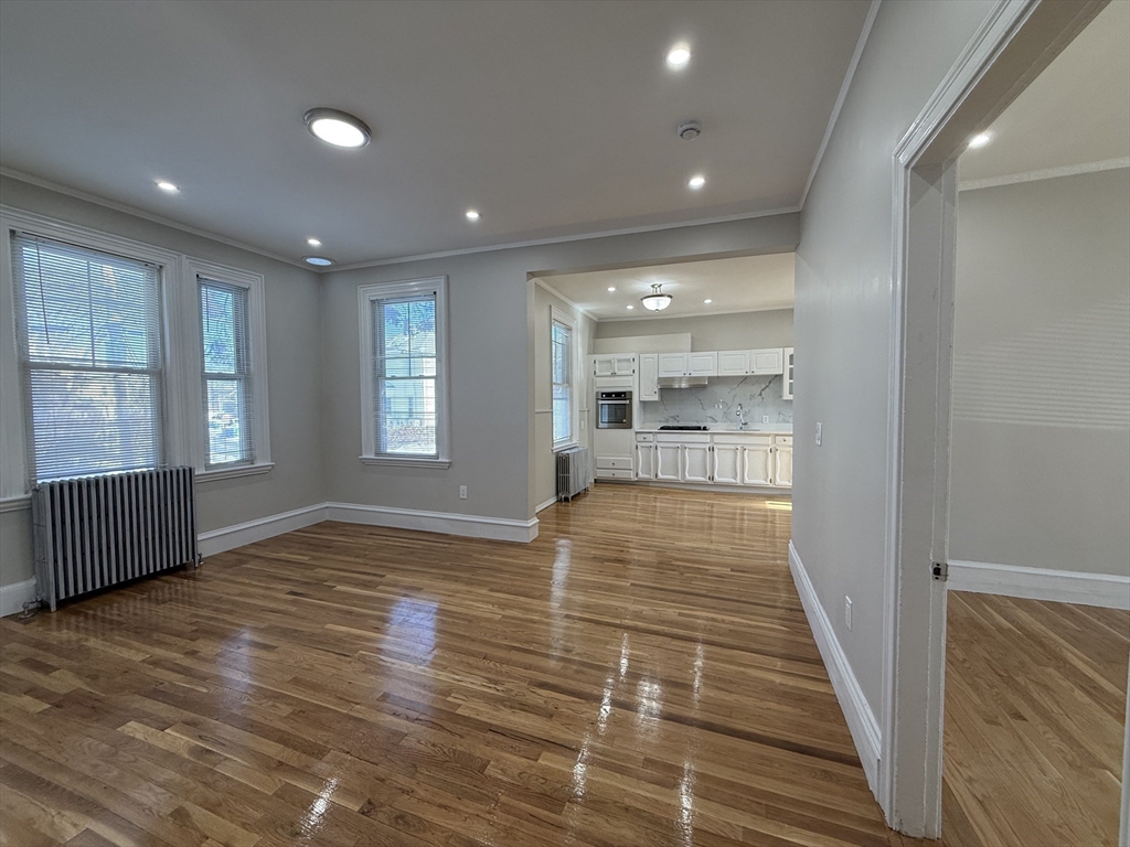 6 Channing Street, Unit 1 Newton, MA 02458 - Photo 4 of 16 a view of an empty room with wooden floor and a window