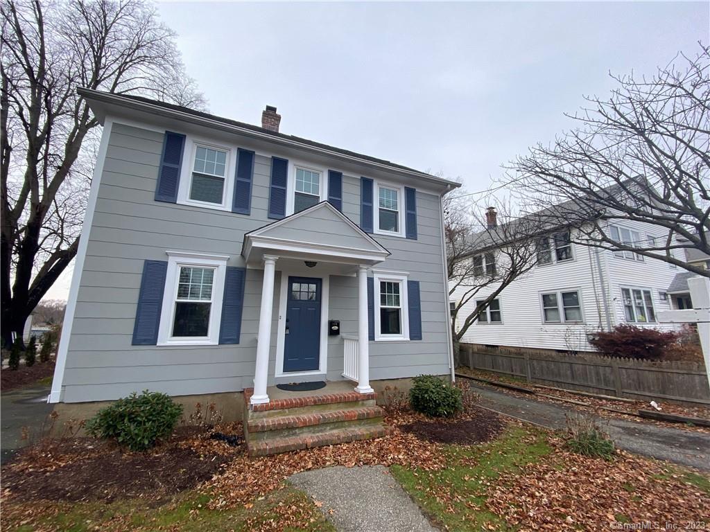 a view of a white house with large windows and large tree