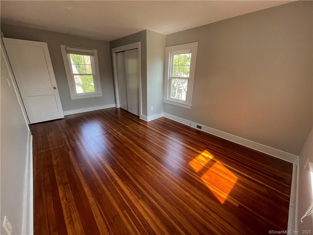 218 Ruane Street Fairfield, CT 06824 - Photo 19 of 26 a view of an empty room with wooden floor and a window