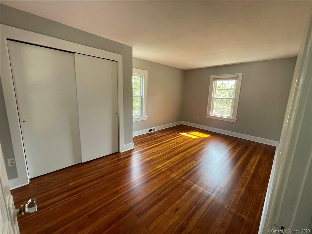 218 Ruane Street Fairfield, CT 06824 - Photo 20 of 26 a view of empty room with window and wooden floor