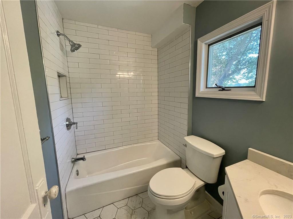 218 Ruane Street Fairfield, CT 06824 - Photo 22 of 26 a white toilet sitting next to a bath tub and a shower