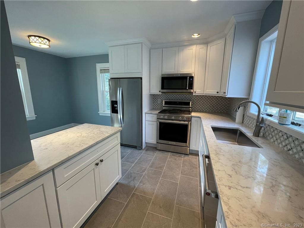 218 Ruane Street Fairfield, CT 06824 - Photo 5 of 26 a kitchen with stainless steel appliances granite countertop a sink stove and refrigerator