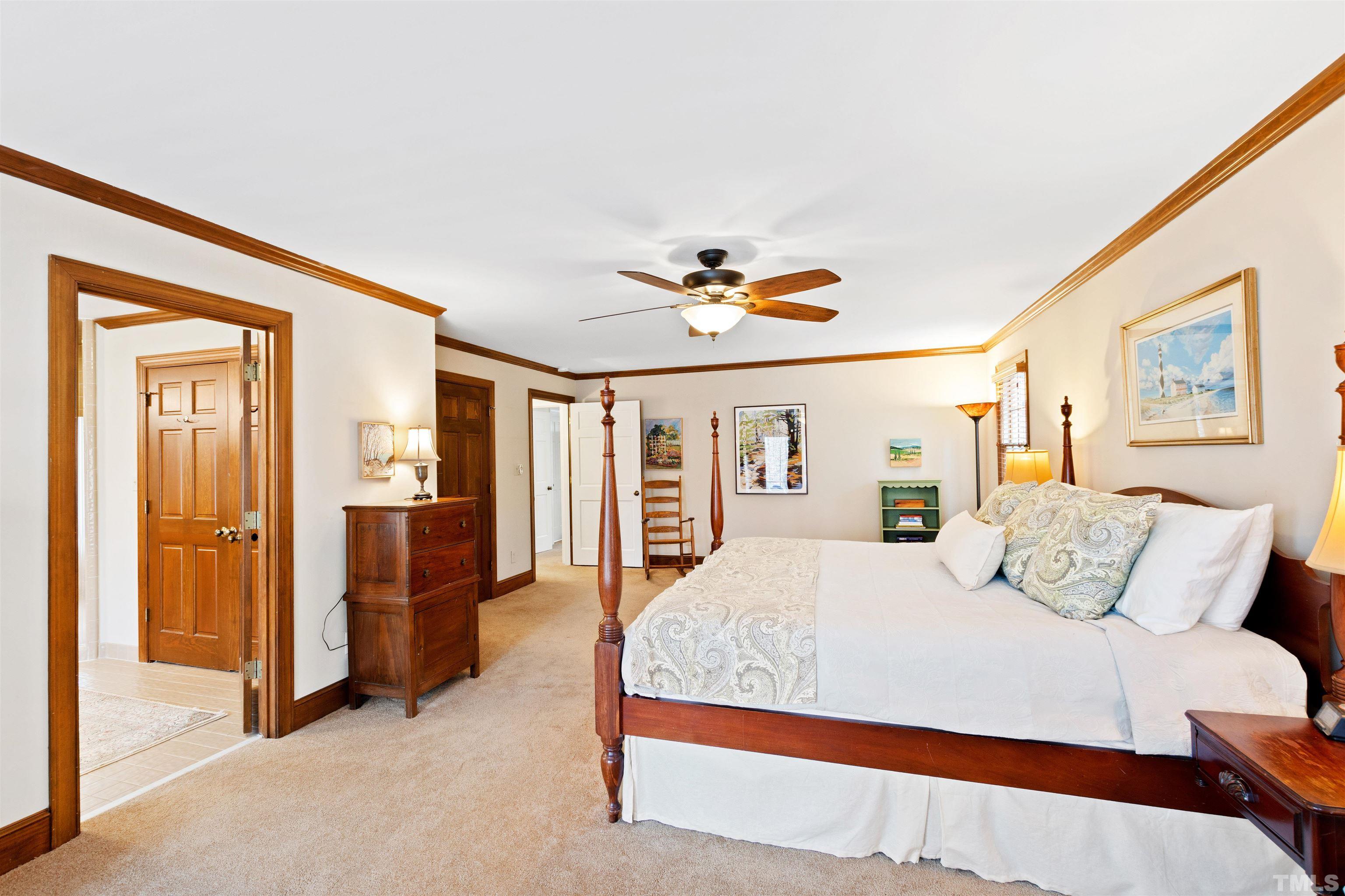 9429 Barton Creek Road Raleigh, NC 27615 - Photo 30 of 78 a bedroom with a large bed and a chandelier