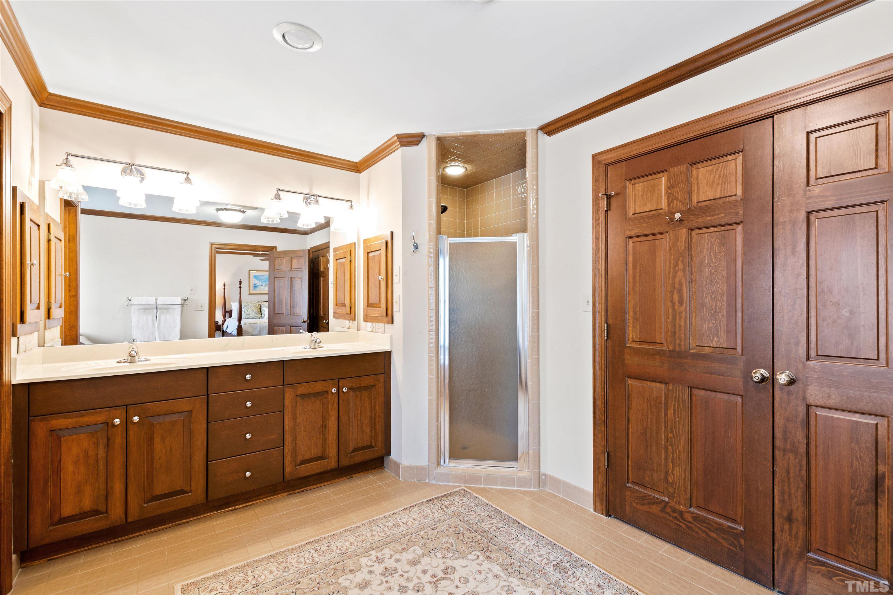 9429 Barton Creek Road Raleigh, NC 27615 - Photo 32 of 78 a spacious bathroom with a double vanity sink a mirror and a shower