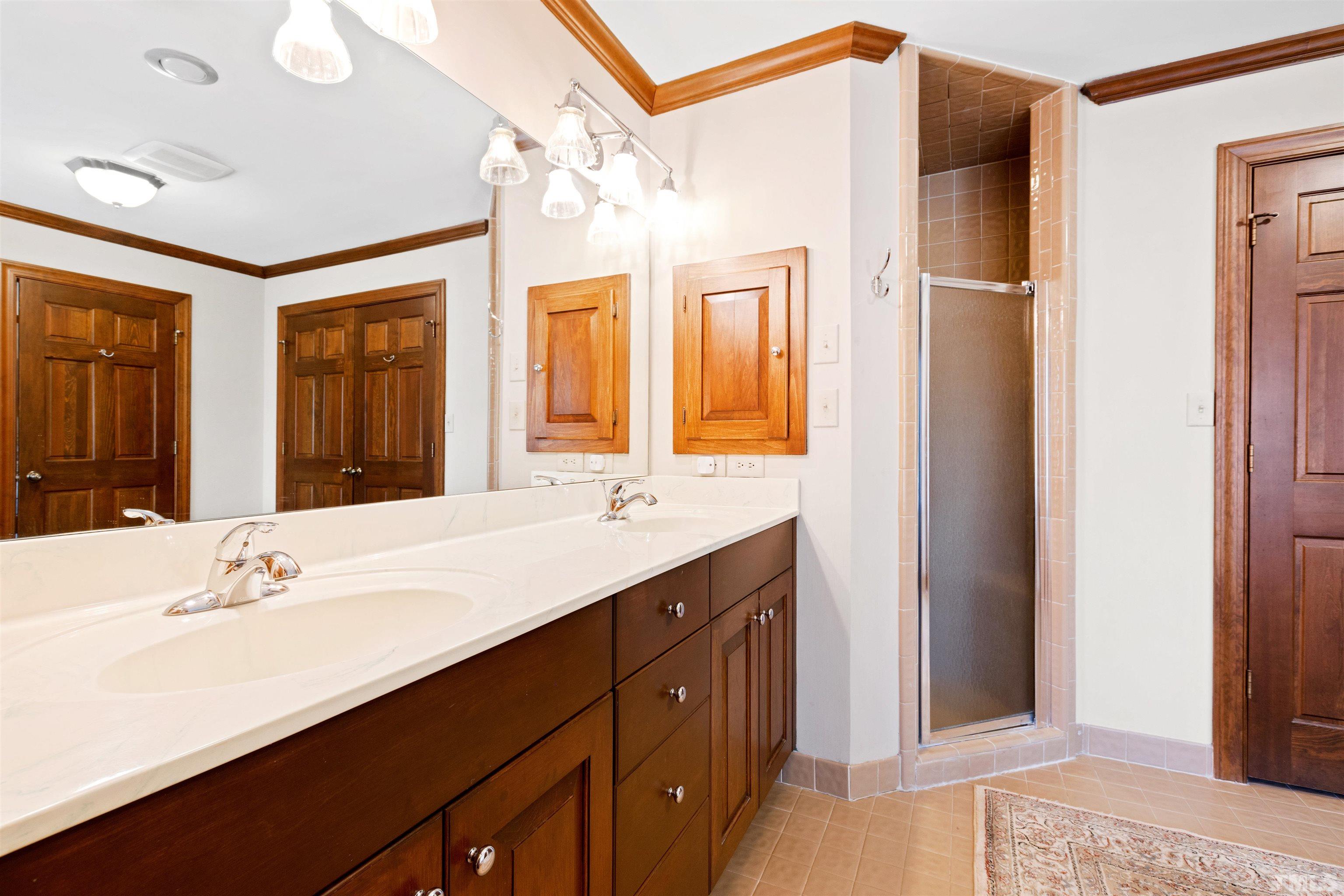 9429 Barton Creek Road Raleigh, NC 27615 - Photo 33 of 78 a bathroom with a sink double vanity granite tub shower and a mirror