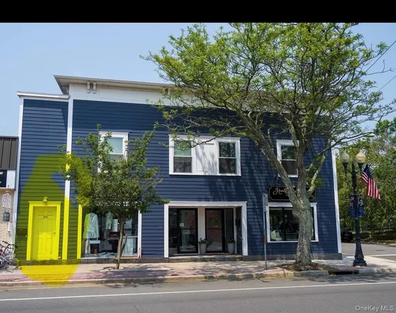 a front view of a house with a tree