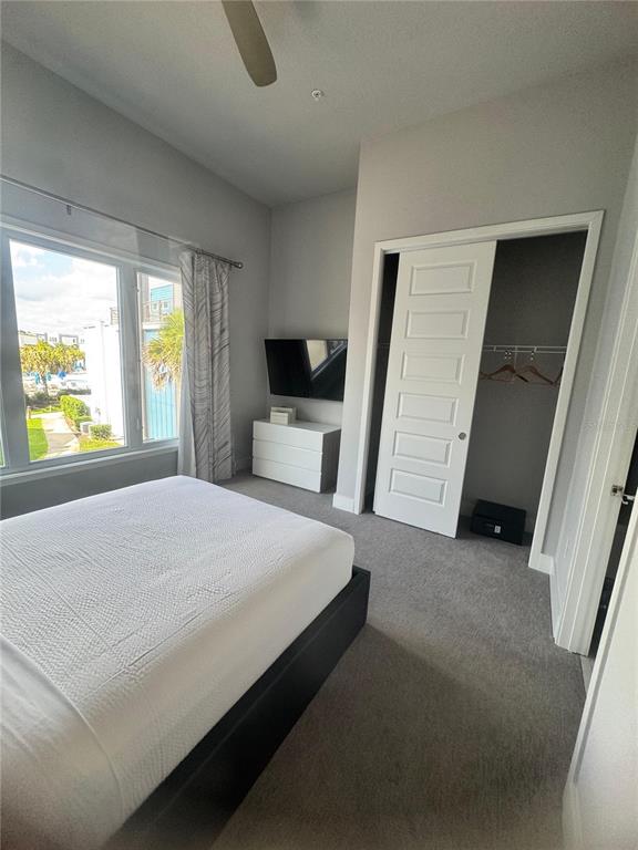 7770 Sandy Ridge Drive, Unit 210 Reunion, FL 34747 - Photo 26 of 42 a bedroom with a bed and a flat tv screen on dresser