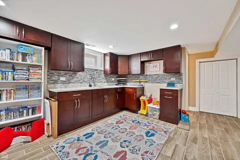 a kitchen with stainless steel appliances granite countertop a refrigerator and a wooden floor