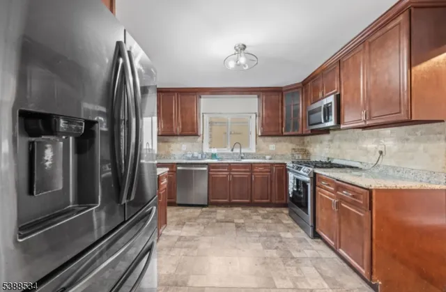 a kitchen with stainless steel appliances granite countertop a refrigerator and a stove top oven
