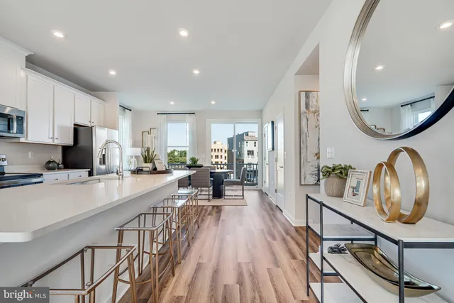 a very nice looking kitchen with kitchen island granite countertop lots of wooden cabinets a sink a stove a dining table and chairs