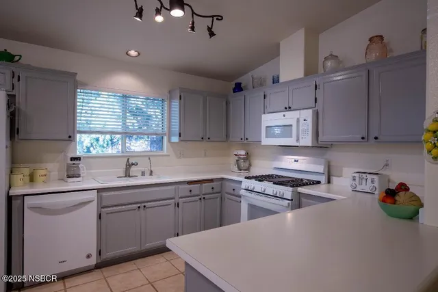 a kitchen with kitchen island a sink stainless steel appliances and cabinets