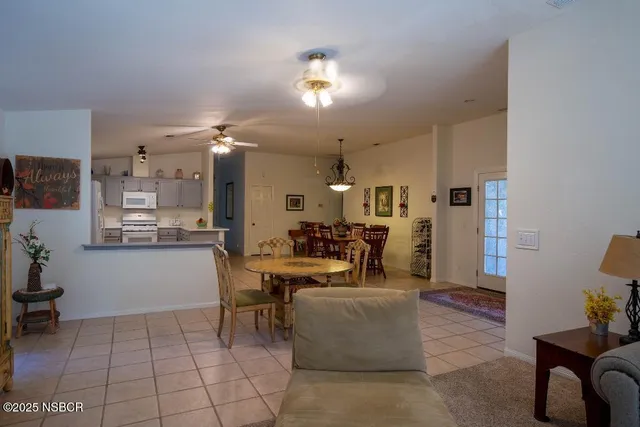 a living room with couches and kitchen view with wooden floor