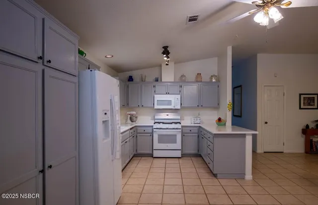 a kitchen with a sink a refrigerator and cabinets