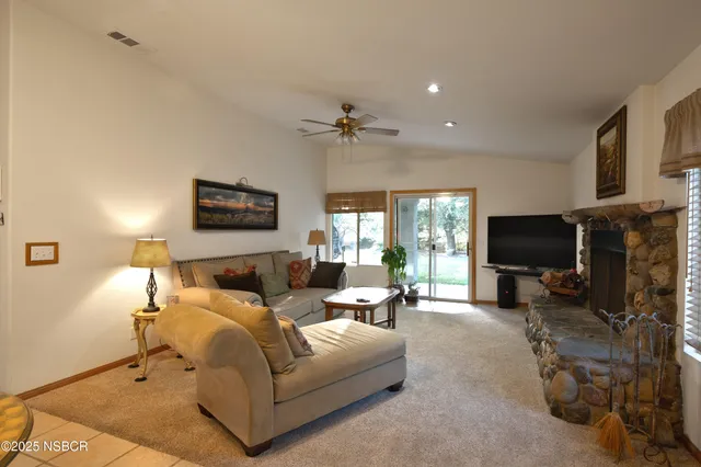 a living room with furniture a flat screen tv and a fireplace