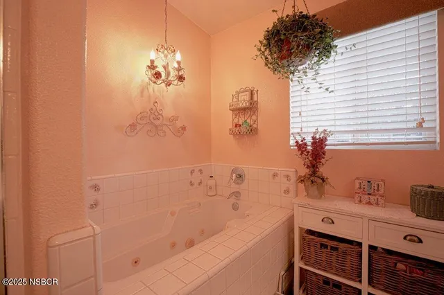 a bathroom with a bathtub sink and mirror
