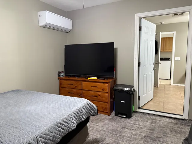 a bedroom with a bed and a flat screen tv