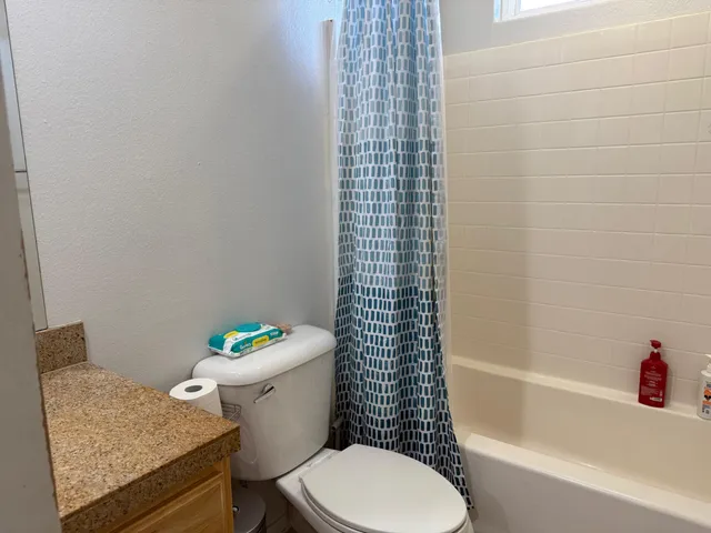 a white toilet sitting next to a bath tub