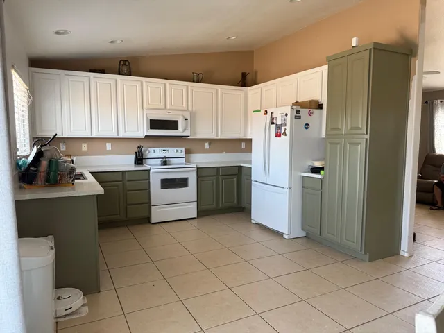 a kitchen with a refrigerator a sink and cabinets