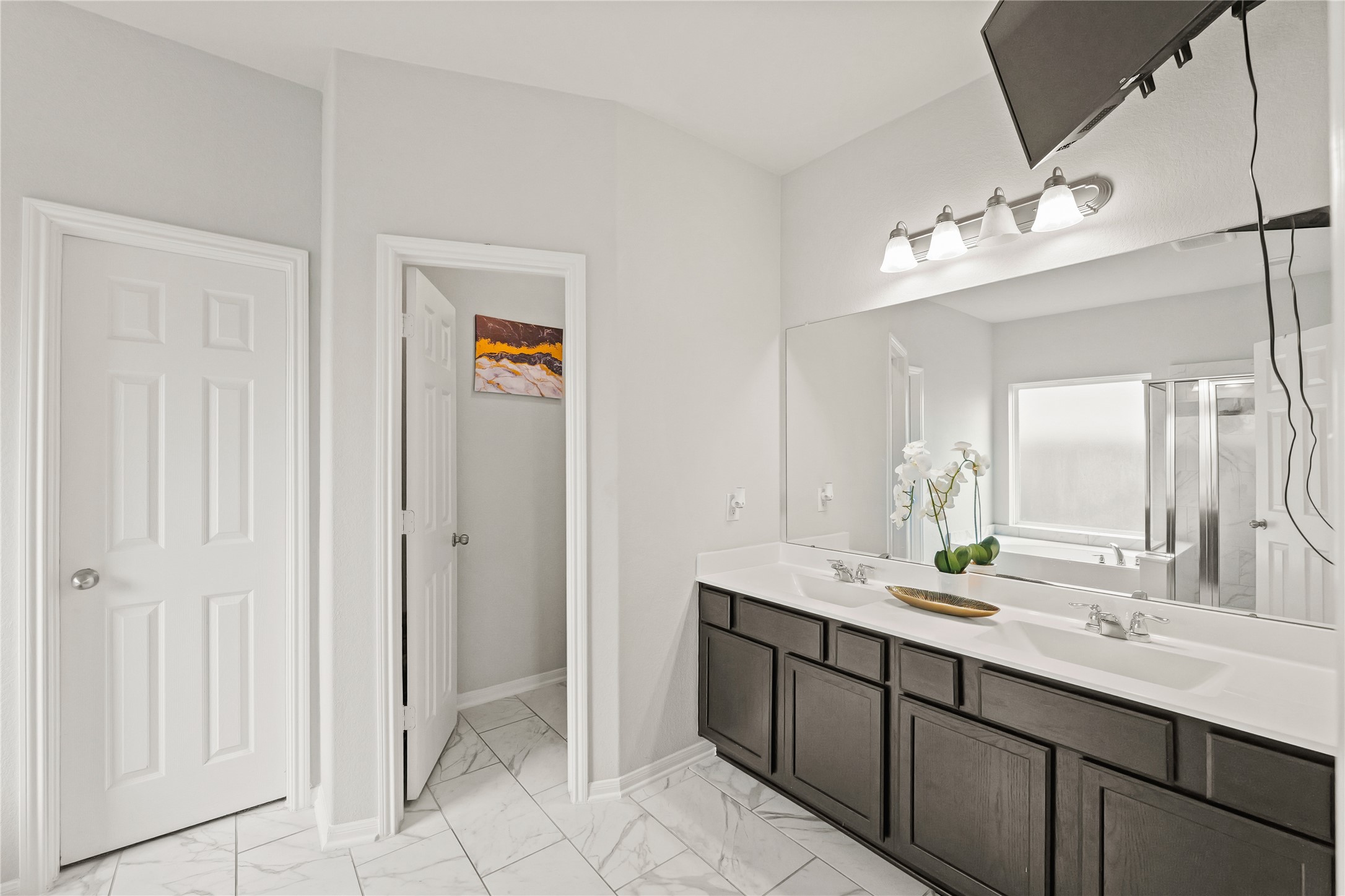 11107 Larkspur Dale Houston, TX 77044 - Photo 20 of 36 a bathroom with double vanity sinks a vanity a lamp and a mirror