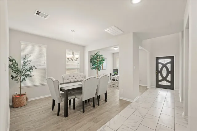 a view of a a dining room with furniture window and wooden floor