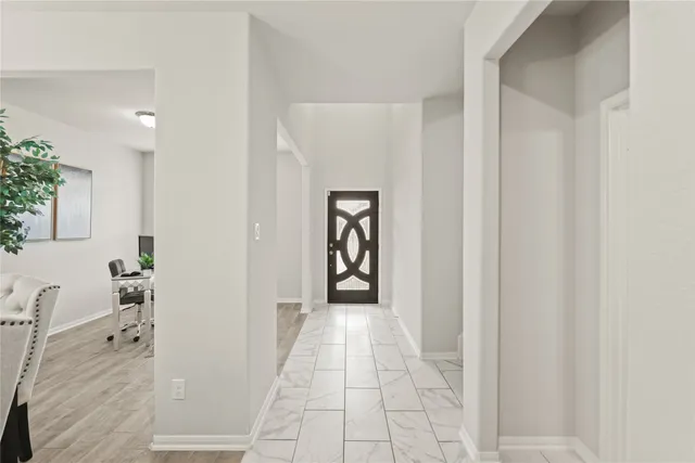 a view of a hallway with wooden floor and windows