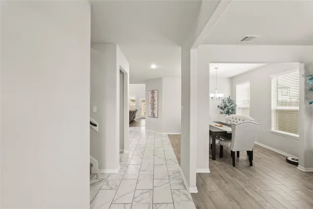 a view of a hallway to a livingroom and a dining room with furniture