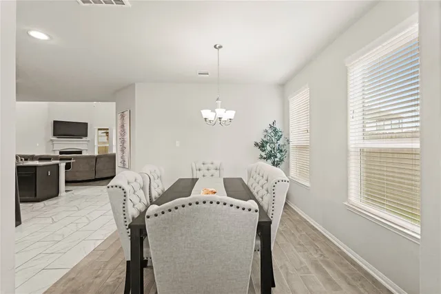 a view of a dining room with furniture and chandelier