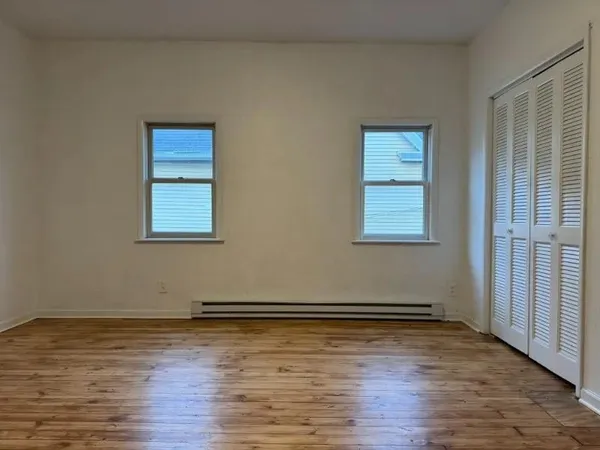 a view of a room with wooden floor and cabinet