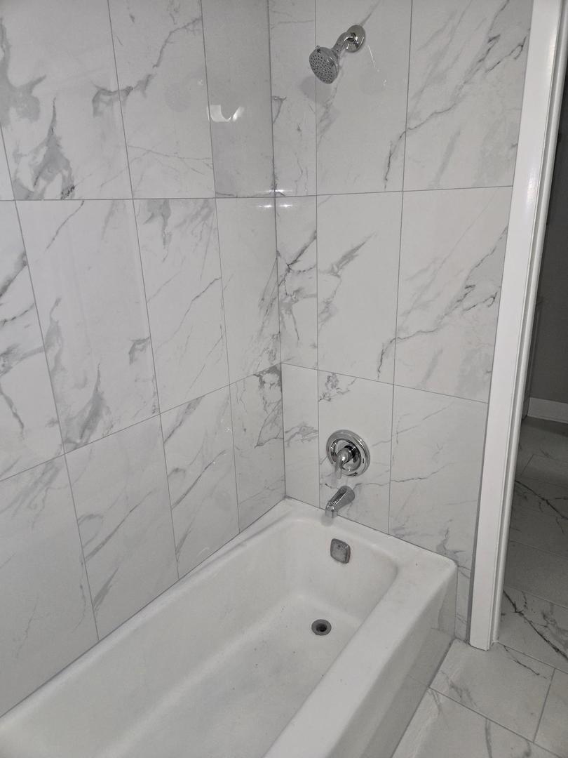 1808 Fayette Walk, Unit H Hoffman Estates, IL 60169 - Photo 9 of 11 a bathroom with a bathtub