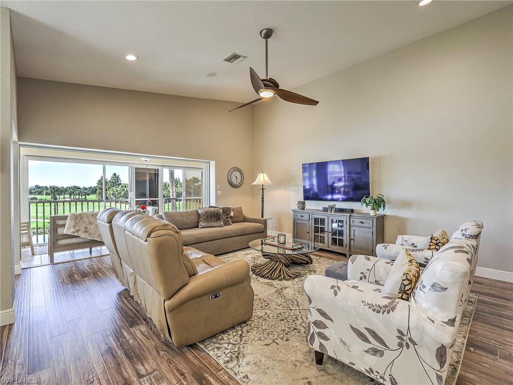 8460 Southbridge Drive, Unit 2 Estero, FL 33967 - Photo 11 of 42 a living room with furniture a flat screen tv and a floor to ceiling window