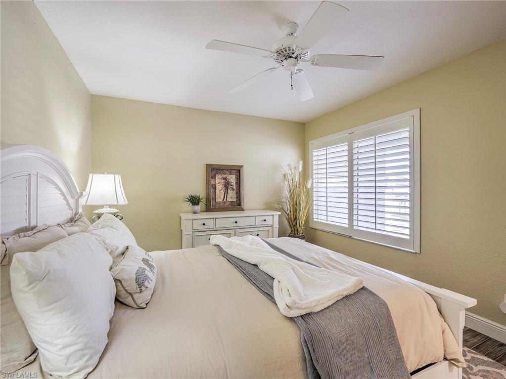 8460 Southbridge Drive, Unit 2 Estero, FL 33967 - Photo 29 of 42 a bedroom with a bed and a chandelier