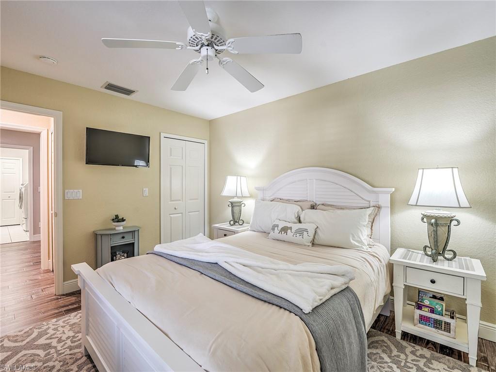 8460 Southbridge Drive, Unit 2 Estero, FL 33967 - Photo 30 of 42 a bedroom with a bed and a chandelier