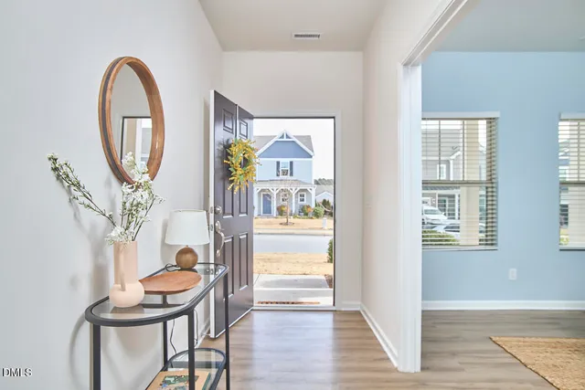 a view of a livingroom with furniture mirror and wooden floor