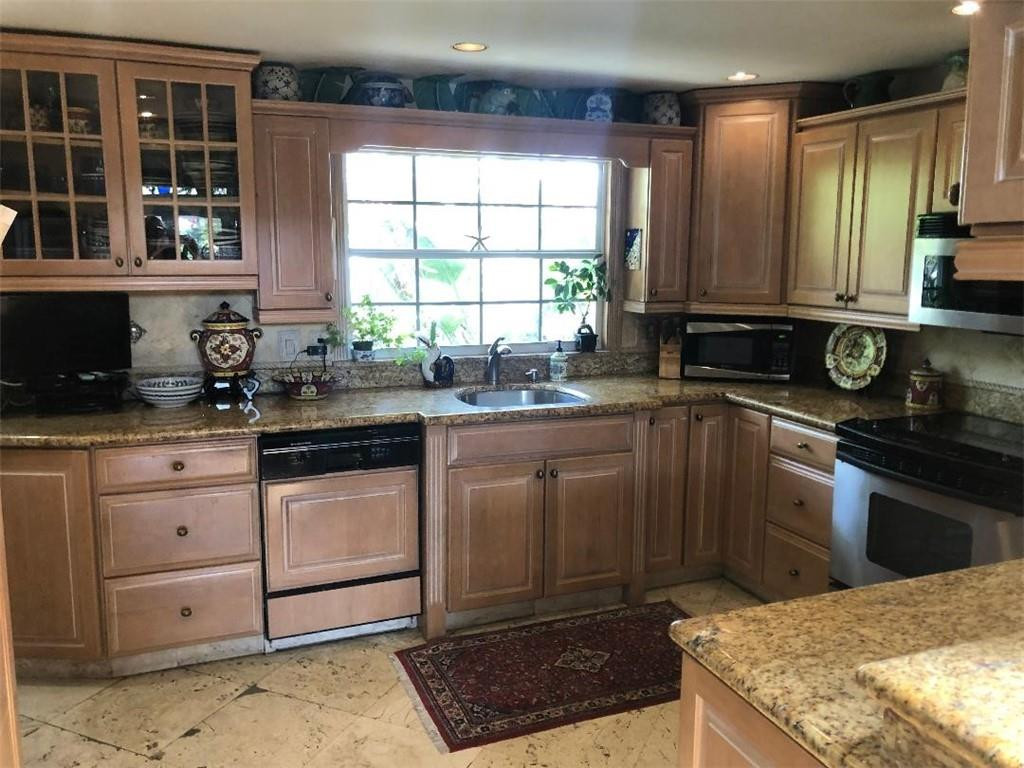 2713 Northeast 30th Avenue Lighthouse Point, FL 33064 - Photo 4 of 22 a kitchen with stainless steel appliances granite countertop a sink stove and cabinets