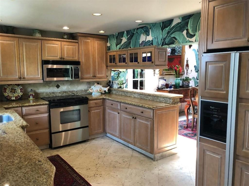 2713 Northeast 30th Avenue Lighthouse Point, FL 33064 - Photo 5 of 22 a kitchen with stainless steel appliances granite countertop a stove a sink and a refrigerator