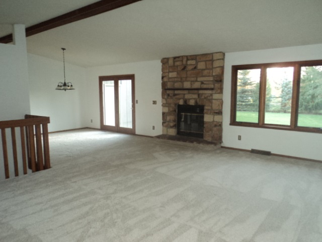 12236 Tresemer Road Roscoe, IL 61073 - Photo 2 of 9 a view of an empty room with a fireplace and a window