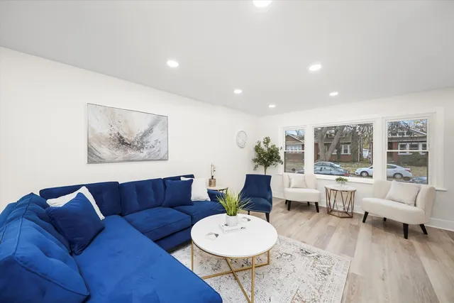a living room with furniture a table and a large window