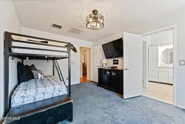 a spacious bedroom with a bed and a chandelier